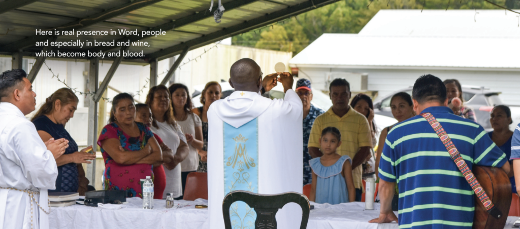 Priest holds host at Mass